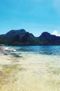 Scenic view of sea and mountains against sky