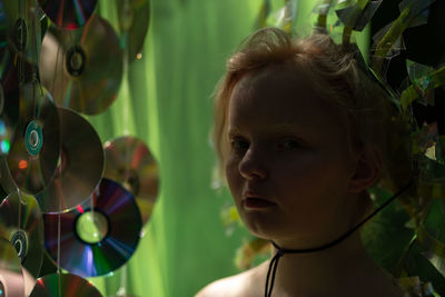 Close-up of girl looking away in a neon green handmade crown