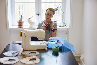 Woman wearing mask on table at home