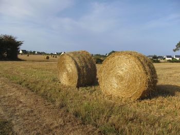 Hay bales on field against sky