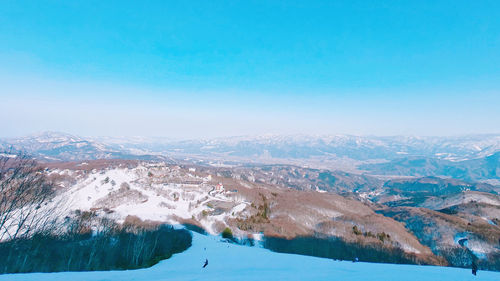 Scenic view of snowcapped mountains against blue sky