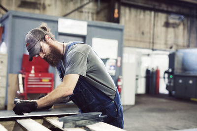 Manual worker using hammer and chisel in steel factory