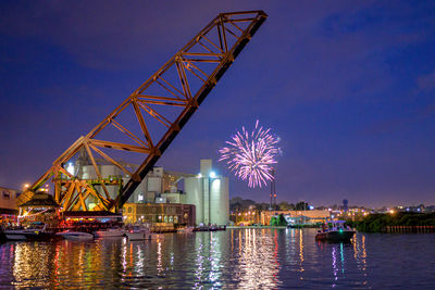 Firework display over river at night