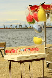 Close-up of multi colored on table by sea against sky