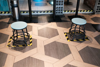 High angle view of social distancing chairs on floor tiles