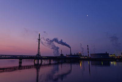 Smoke emitting from factory against sky