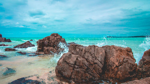 Rocks on sea shore against sky