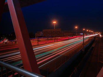 Light trails on road against sky at night