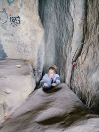 Rear view of woman sitting on rock