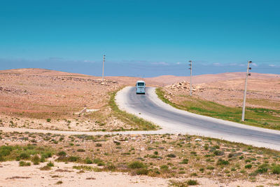 Car on road by land against sky