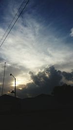 Silhouette of mountain against cloudy sky