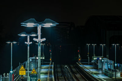 Illuminated railroad station platform at night