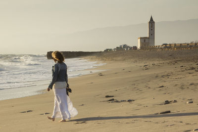 Rear view of woman standing on beach