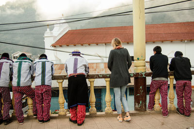 Rear view of people in front of built structure