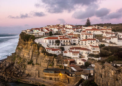 Residential district by sea against sky