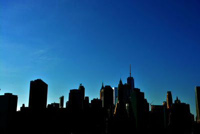 Low angle view of skyscrapers against blue sky