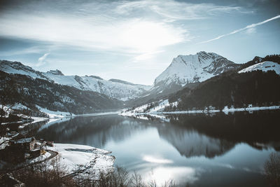 Scenic view of lake and snowcapped mountains against sky