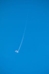 Low angle view of airplane flying against blue sky