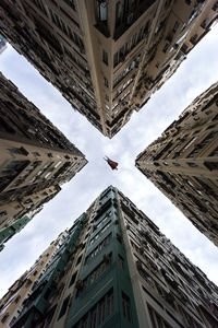 Directly below shot of superhero flying amidst residential buildings against sky