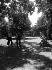 Rear view of people walking on street in city