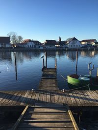 Wooden pier over lake against clear sky