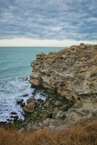 Rock formation on beach against sky