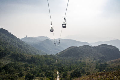 View of overhead cable car over mountains against sky