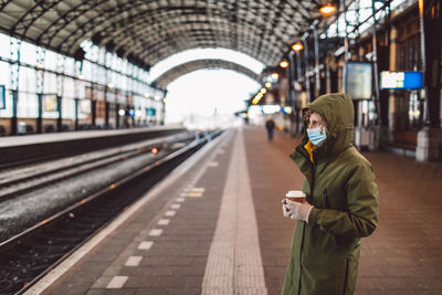 Man standing on railroad station platform