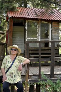 Portrait of young woman standing against building