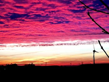 Silhouette electricity pylon against sky during sunset