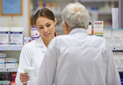 Pharmacist helping with medicine to senior man at pharmacy store