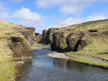 Scenic view of river amidst rocks against sky