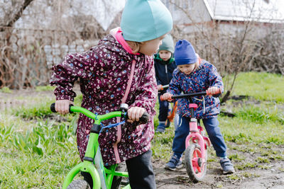 Group of children riding balance bikes outdoors in the garden. childhood in the countryside 