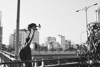 Man photographing on street against buildings in city