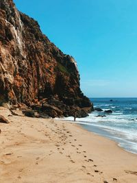 Scenic view of beach against clear blue sky