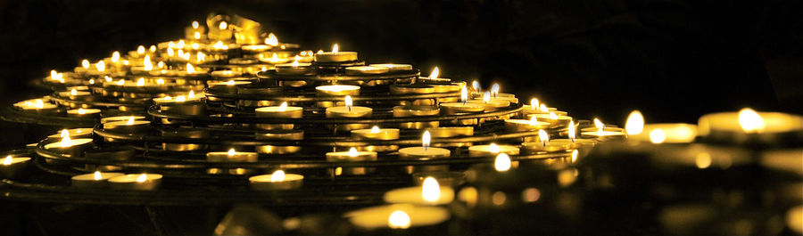 Close-up of illuminated tea light candles at temple