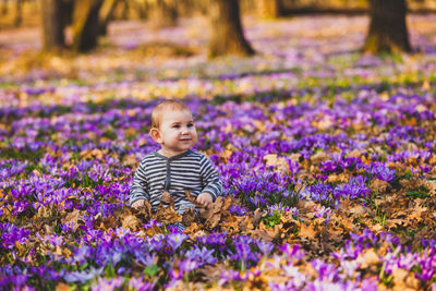 Cute girl sitting on purple flowering plants