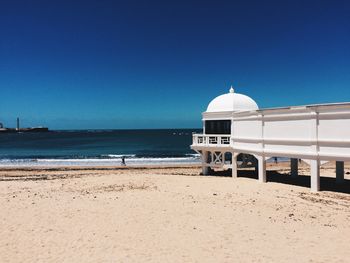 View of beach against clear blue sky