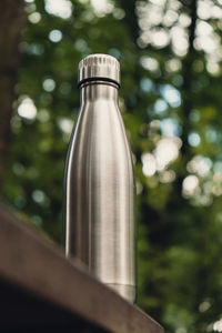 Water bottle. reusable steel thermo water bottle on wooden bench isometric concept. sustainable