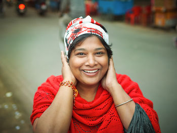 Close-up portrait of cheerful mature woman wearing knit hat while standing on road