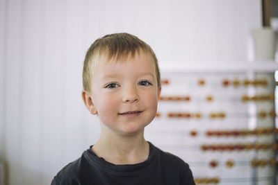 Portrait of smiling boy with blond hair in classroom at kindergarten