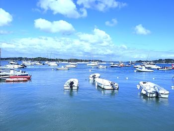 Sailboats moored in sea against sky