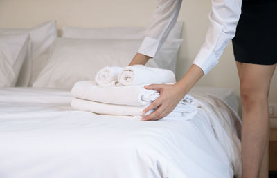 Midsection of woman relaxing on bed