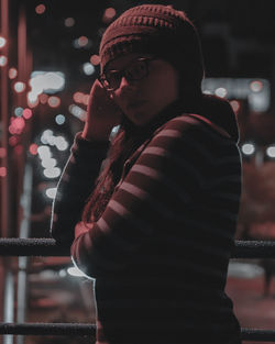 Side view of young man looking away at night