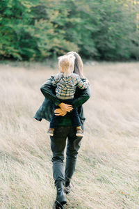 Rear view of woman walking on field