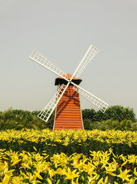 Traditional windmill on field against clear sky