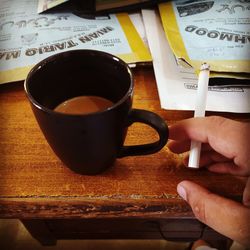 Woman holding coffee cup on table