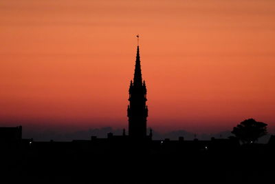 Silhouette of temple building against orange sky