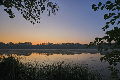 Scenic view of lake against sky at sunset