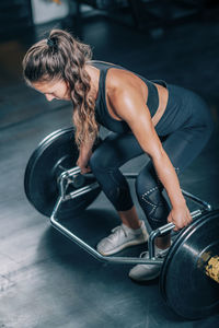 Woman doing trap bar deadlift in the gym.